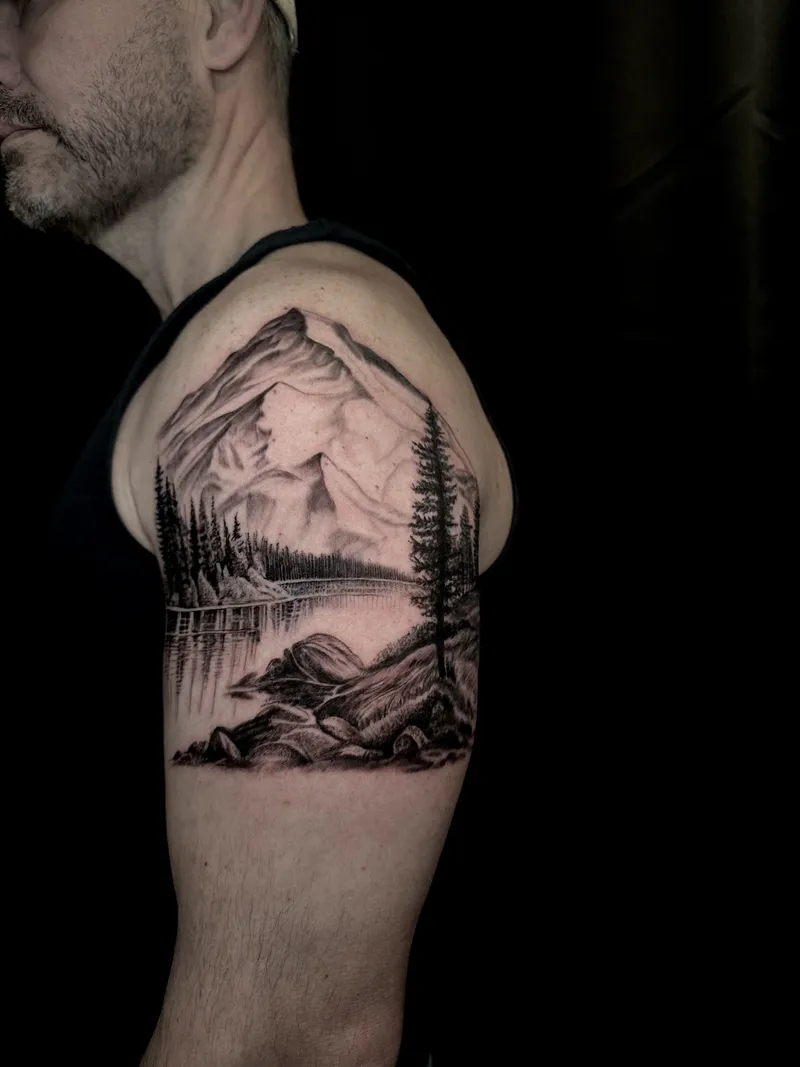 Black and grey mountain range with pines on the upper arm