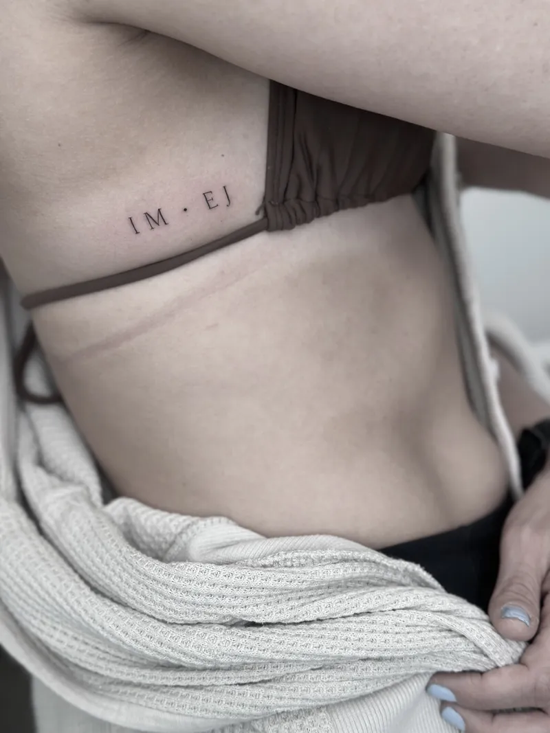 Tiny fine line initials on the ribs